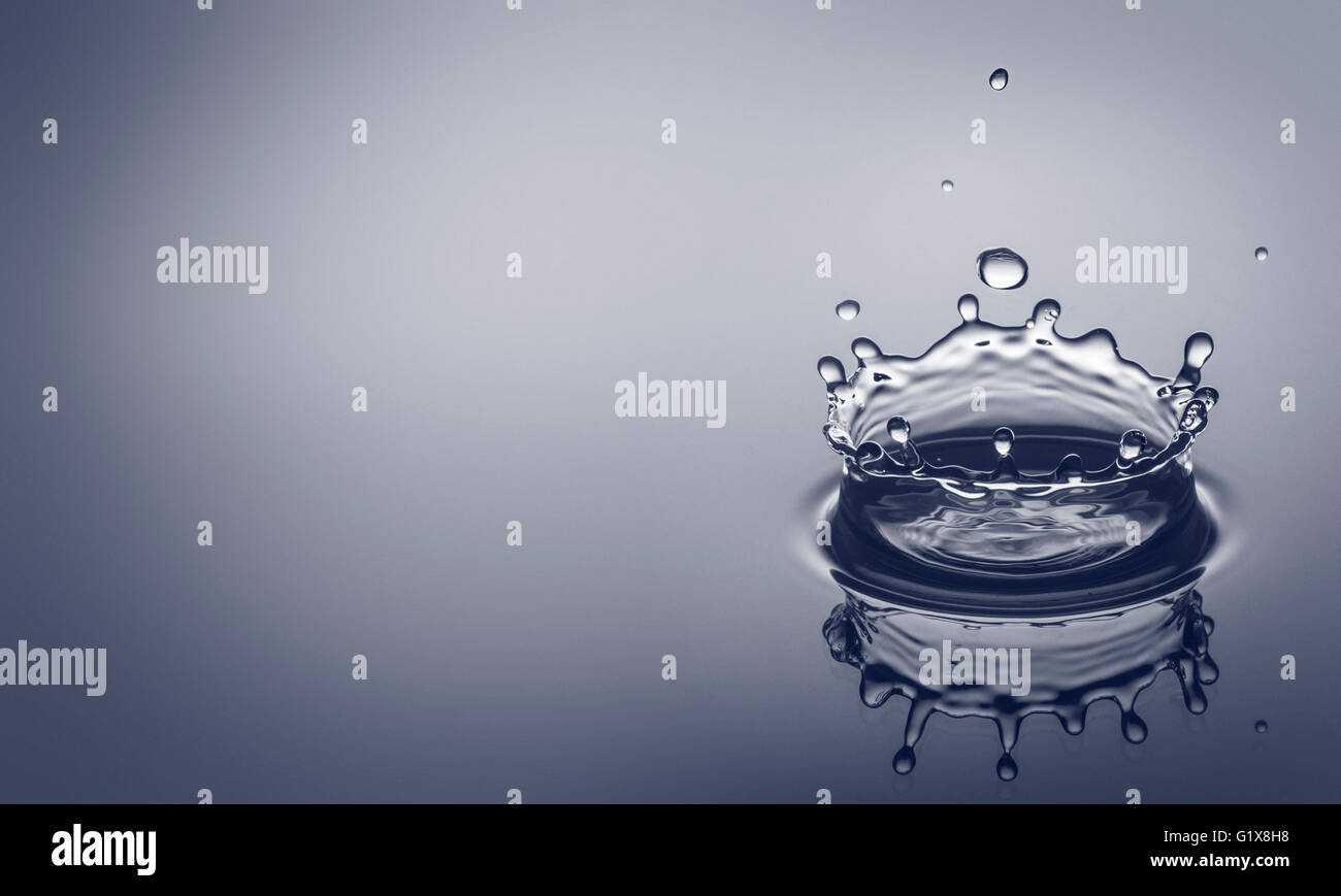 Wasser Tropfen Spritzwasser einen klaren, blauen Hintergrund mit Überlegung und Platz für Ihren Text. Stockfoto