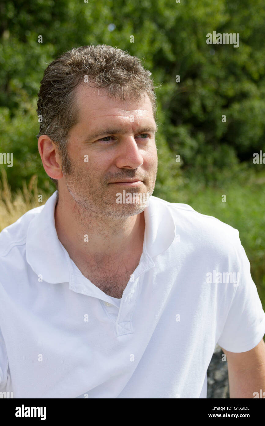 45 - Jahre alter Mann mit Stoppeln genießen einen sonnigen Sommertag im Urlaub in der Natur Stockfoto
