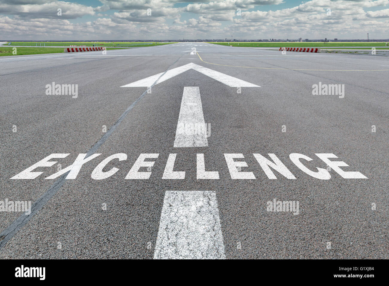 Start-und Landebahn des Flughafens mit Pfeil Leitlinie und Exzellenz Buchstaben auf die Oberfläche gemalt Stockfoto