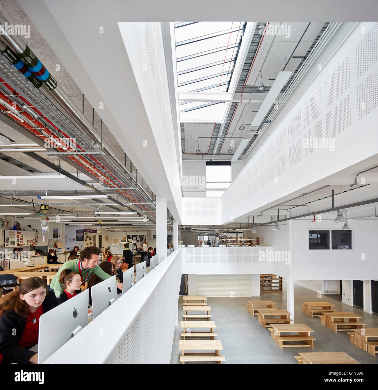 Im ersten Stock es Schreibtisch mit Blick auf doppelter Höhe Volumen. Plymouth Creative School of Art, Plymouth, Vereinigtes Königreich. Architekt: Feilden Clegg Bradley Studios LLP, 2015. Stockfoto