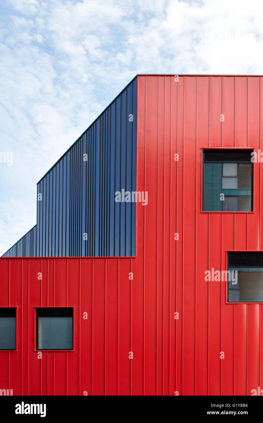 Graue und rote Stahlmantel Außenfassade. Plymouth Creative School of Art, Plymouth, Vereinigtes Königreich. Architekt: Feilden Clegg Bradley Studios LLP, 2015. Stockfoto