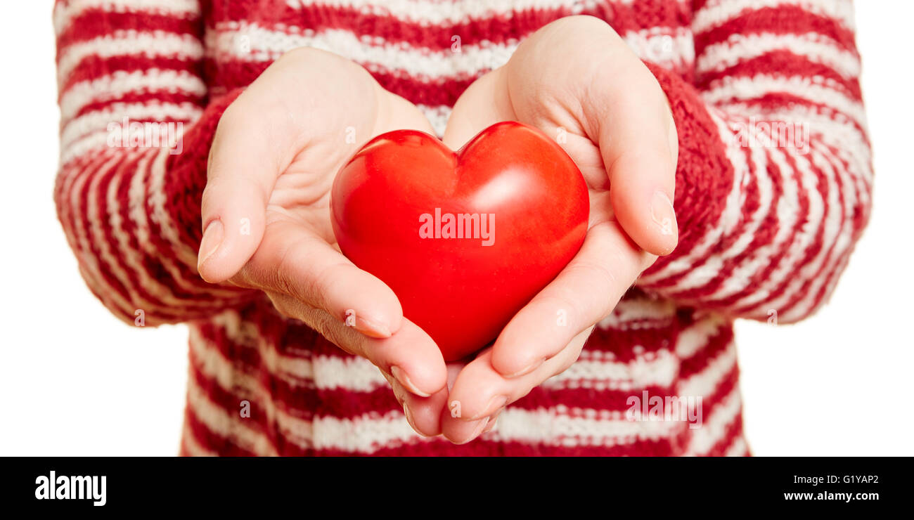 Hände halten ein rotes Herz als Symbol für Liebe und Fürsorge Stockfoto