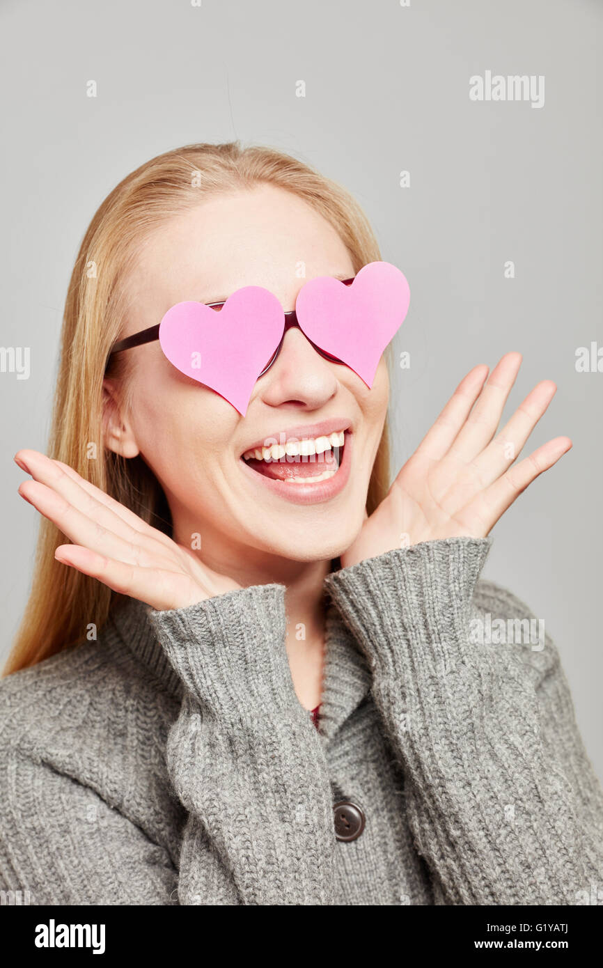 Frau in der Liebe sieht zwei rosa Herzen über die Augen Stockfoto