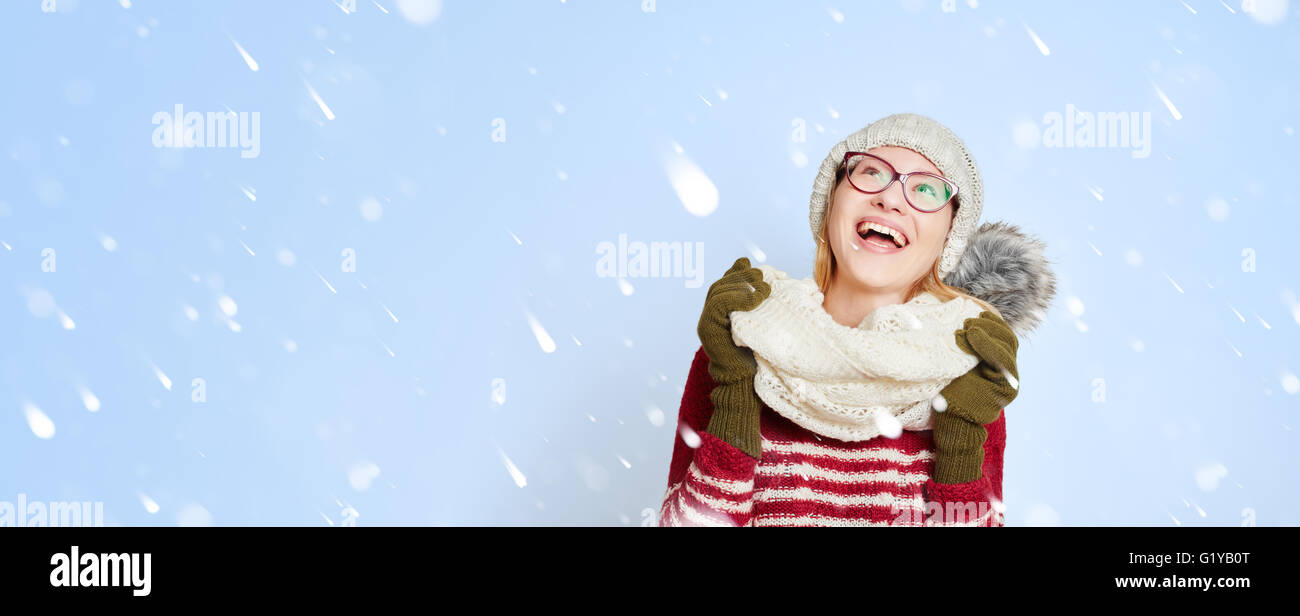 Lächelnde Frau, die im Schnee in der Mitte Schneeflocken im winter Stockfoto