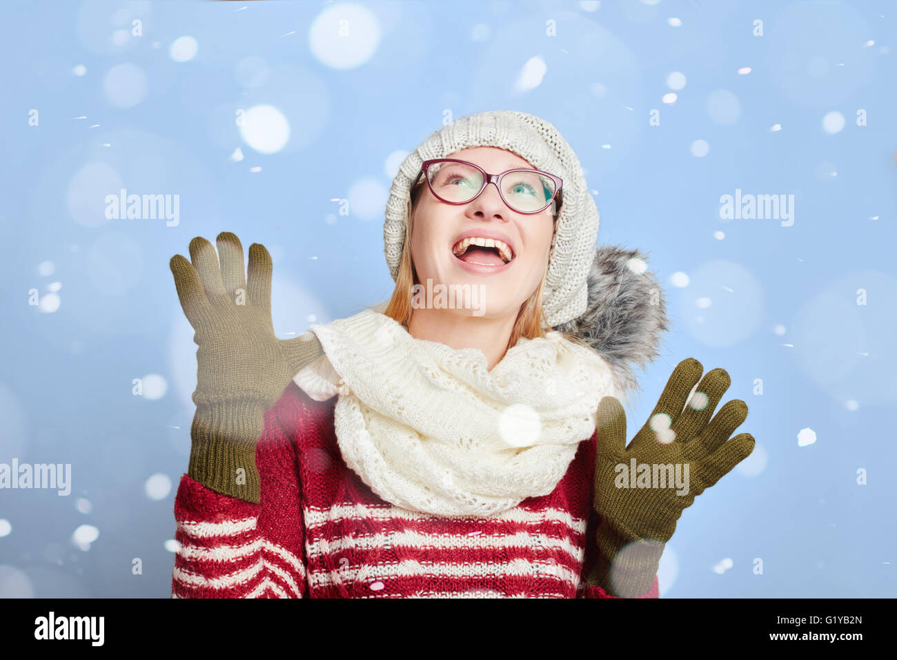Frau mit Mütze und Schal glücklich über den Schnee im winter Stockfoto