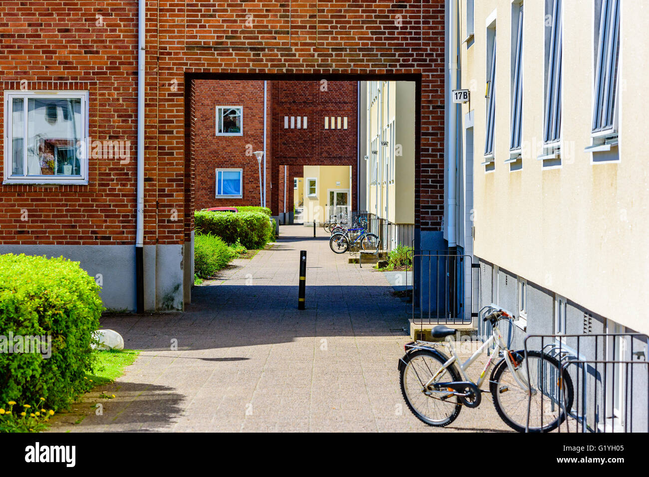 Ronneby, Schweden - 8. Mai 2016: Im freien Durchgang durch Wohnhäuser. Fahrräder parken entlang eines Gebäudes. Stockfoto