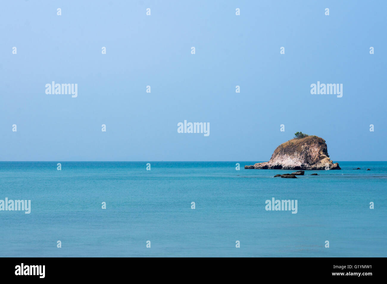 Kleine Insel in der Mitte ein leeres Meer mit einem klaren, blauen Himmel. Stockfoto