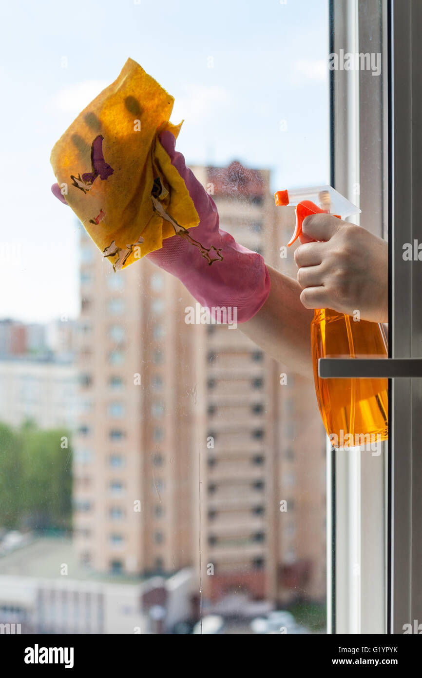 Waschen-home-Fenster - Reiniger wäscht Fensterglas mit Waschmittel im Appartementhaus Stockfoto