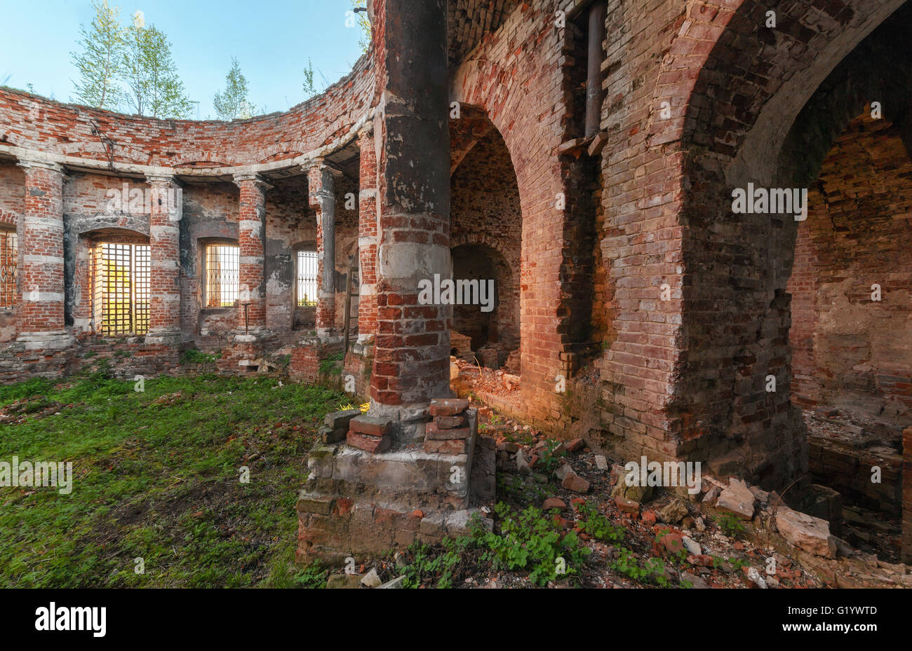 Antiken Rundbau mit Säulen ohne eine Kuppel. Die Ziegel Ruinen des Innenraums von einem verlassenen Tempel mit Rasen bewachsen Stockfoto