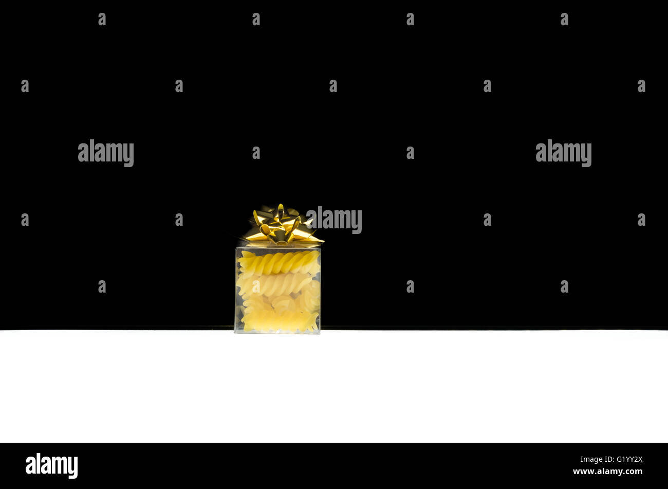 Transparente Geschenk-Box mit einem goldenen Band Rosette mit typisch italienischen Nudeln Stockfoto