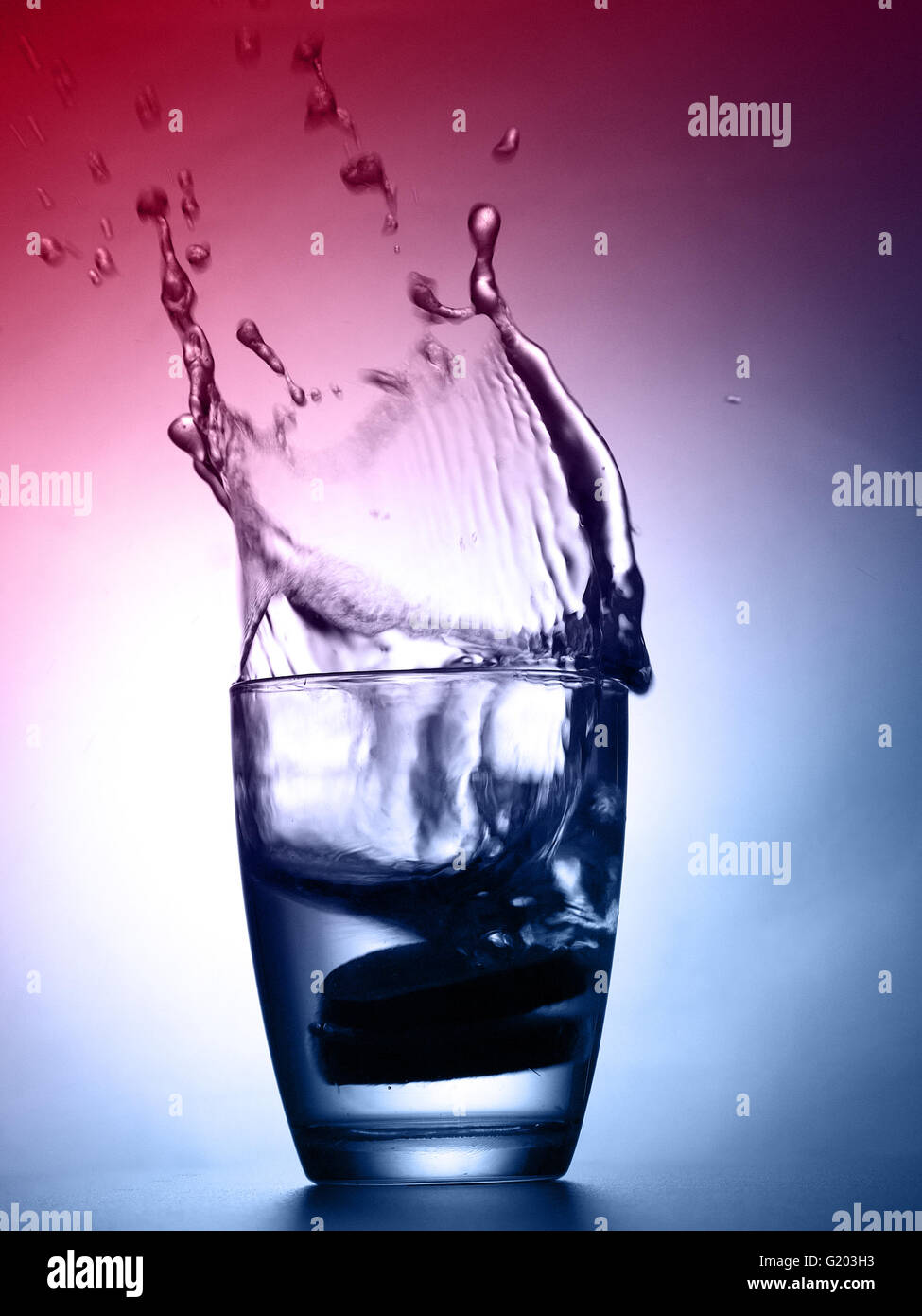 zwei Zitrone Tropfen und Spritzer in ein Glas Wasser Stockfoto