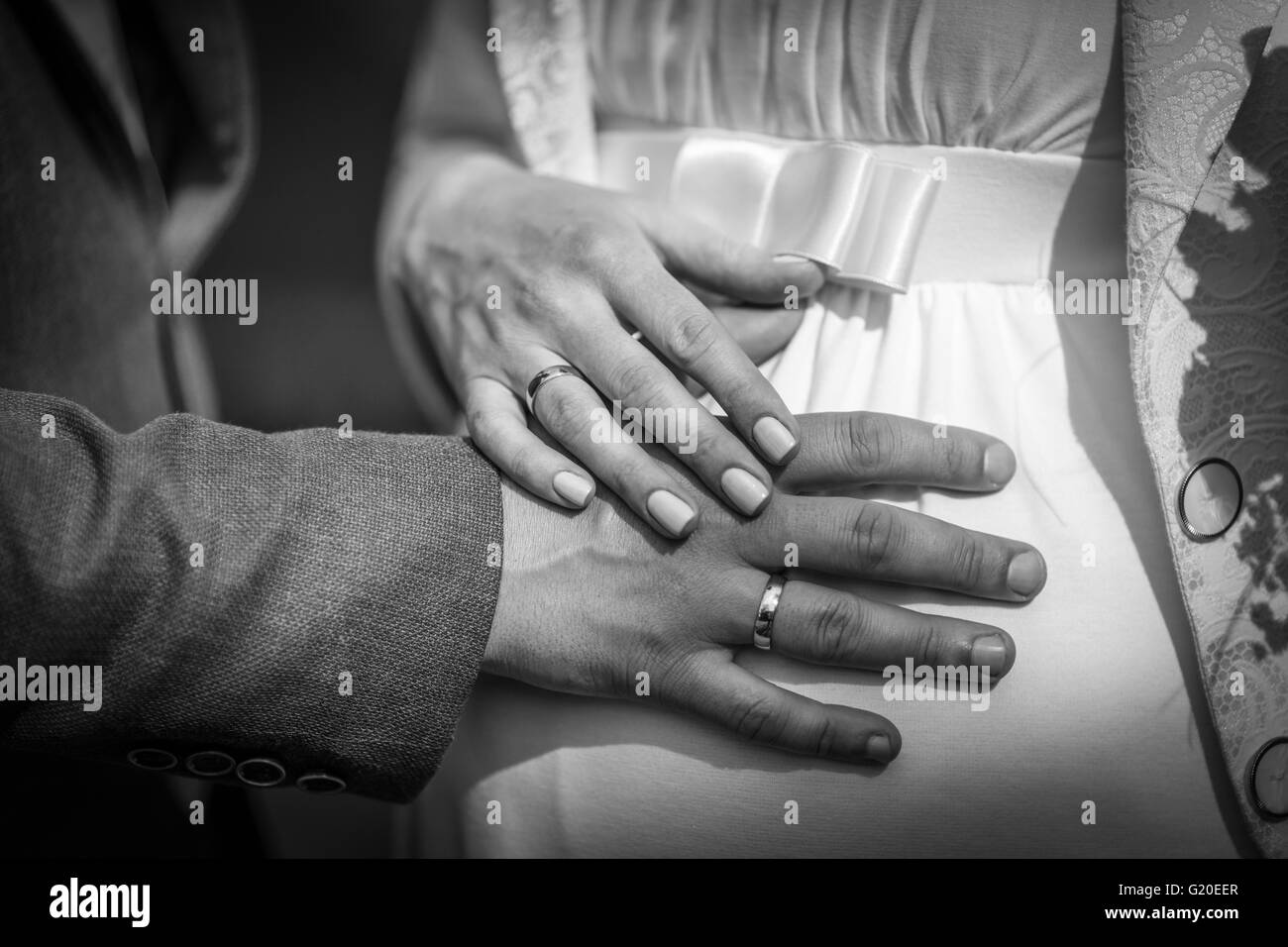 Hände mit Trauringe auf schwangere Braut Stockfoto