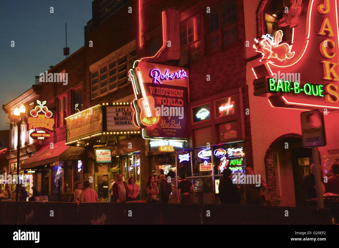 Leuchtreklamen für die Honky Tonks, Restaurants und Geschäften locken Touristen in der Nacht am Broadway in Nashville, TN, Music City USA Stockfoto