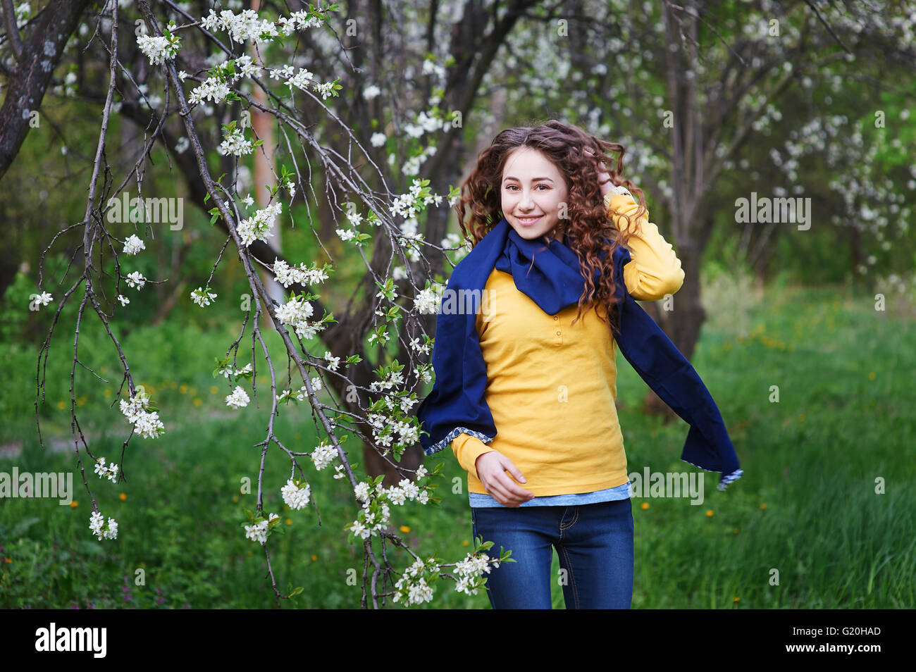 schöne junge Frau, die zu Fuß in einer blühenden Frühlingsgarten Stockfoto