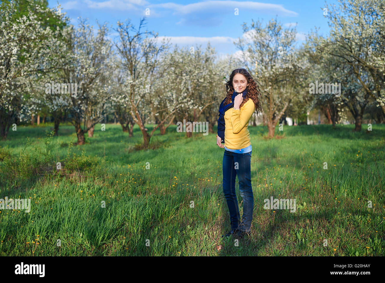 schöne junge Frau, die zu Fuß in einer blühenden Frühlingsgarten Stockfoto