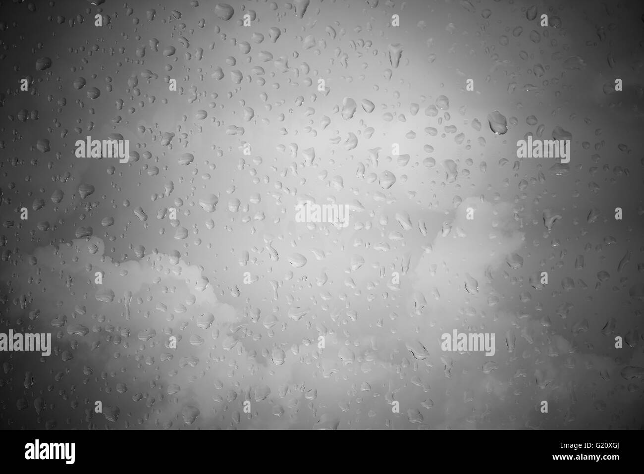 Regen-Tropfen mit bewölktem Himmel in schwarz / weiß, Konzept für Traurigkeit Stockfoto