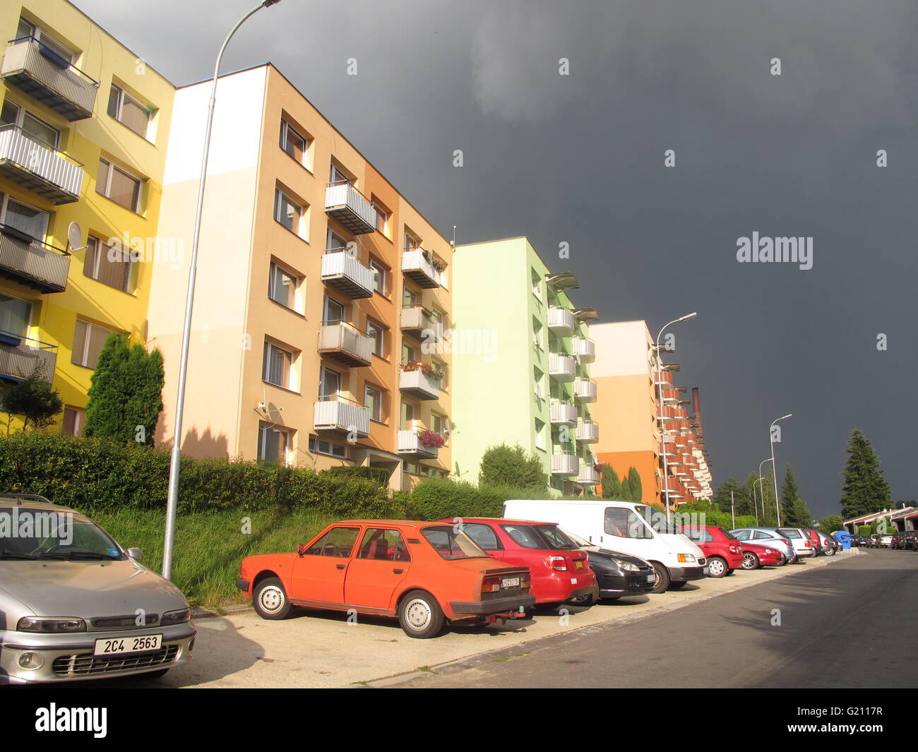 Dacice - Tschechische gehisst, bunte konkrete Mehrfamilienhäuser mit Autos Parkedin vorne Stockfoto