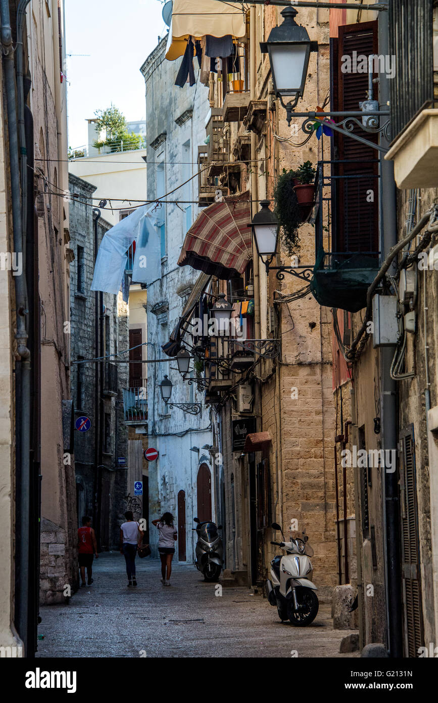 Drei Personen zu Fuß entlang einer Straße von Bari Vecchia. Stockfoto