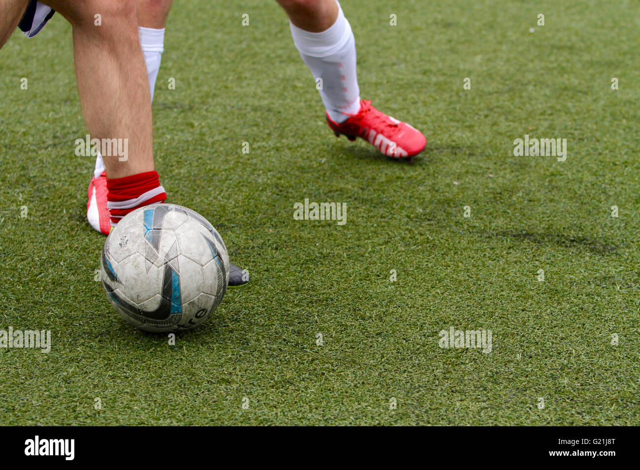 Die Beine der 2 Spieler spielen Fußball (Fußball) mit einem Spieler besitzen die Kugel Stockfoto