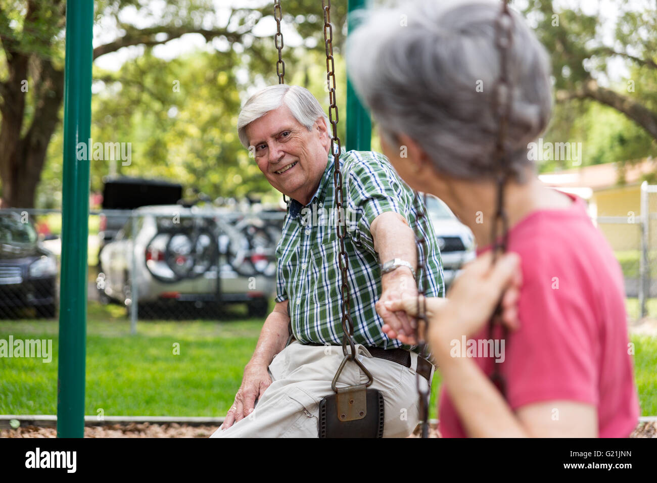 Senior paar halten die Hände auf schwingen Park Spaß Stockfoto