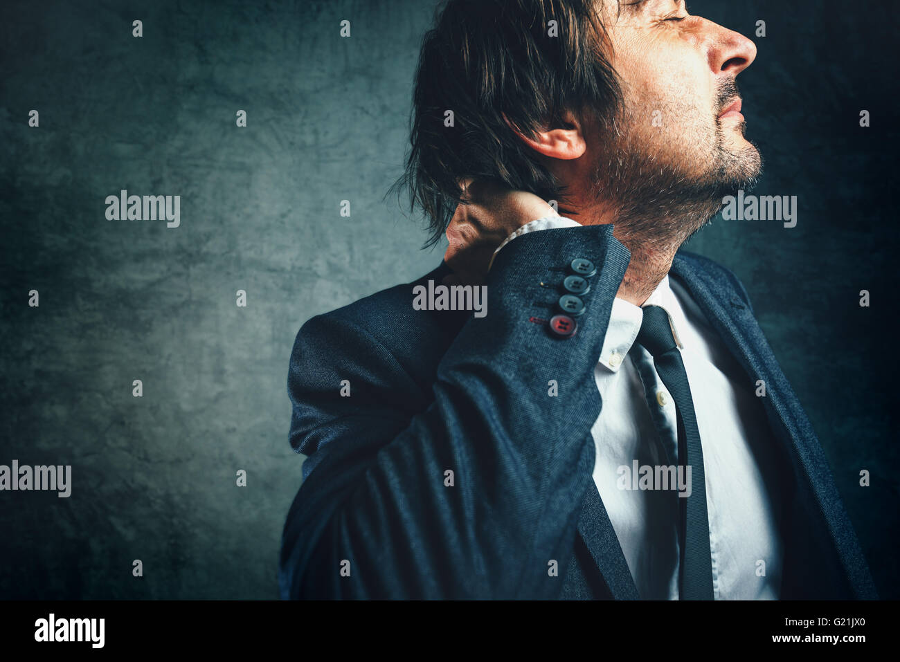 Schmerzen im Nacken eines Geschäftsmannes, betonte Unternehmer im eleganten Anzug, die unter Neckache leiden. Stockfoto