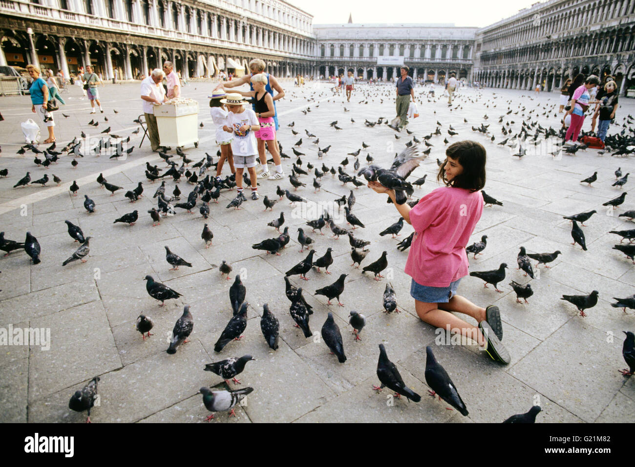 Kind füttern Tauben in St Mark´s Quadratmeter Stockfoto