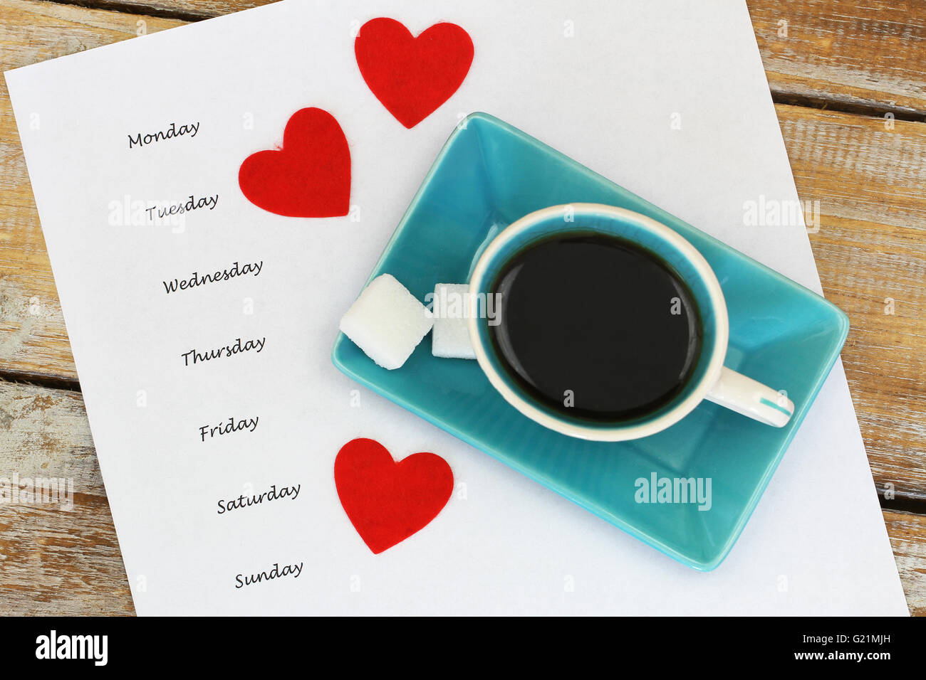 Wochentage auf weißes Blatt Papier mit Tasse Kaffee mit drei roten Herzen geschrieben Stockfoto