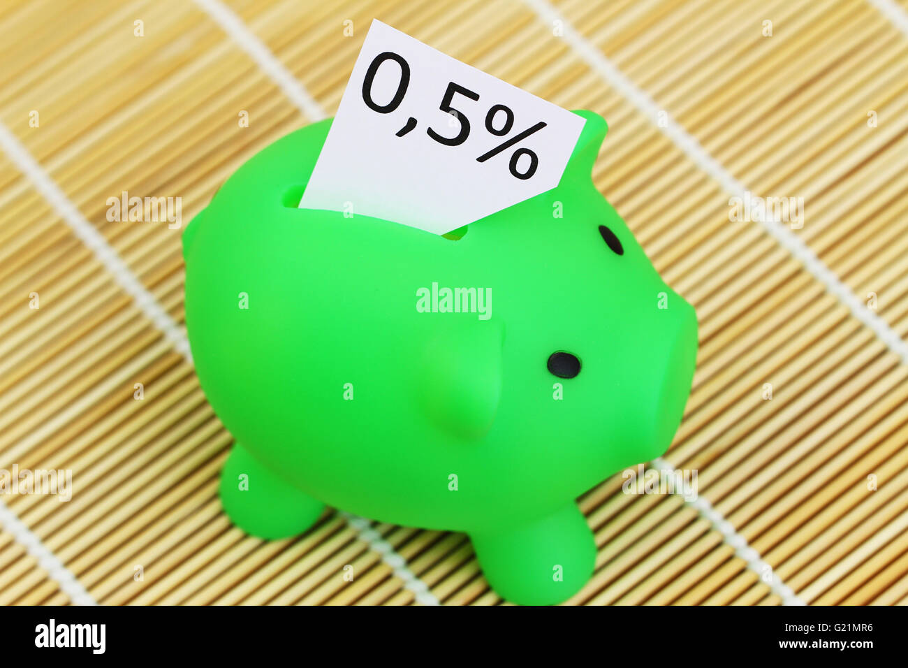 Sparschwein mit Note mit 0,5 % Zins kleben aus ihm heraus Stockfoto