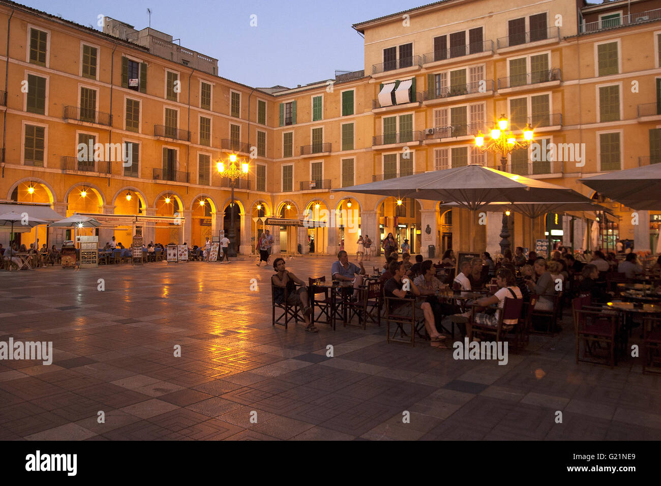 ein schönes Bild von Touristen im Café Plaza Mayor bei Sonnenuntergang in der Stadt Palma, Palma De Mallorca, Spanien, am Meer Stockfoto