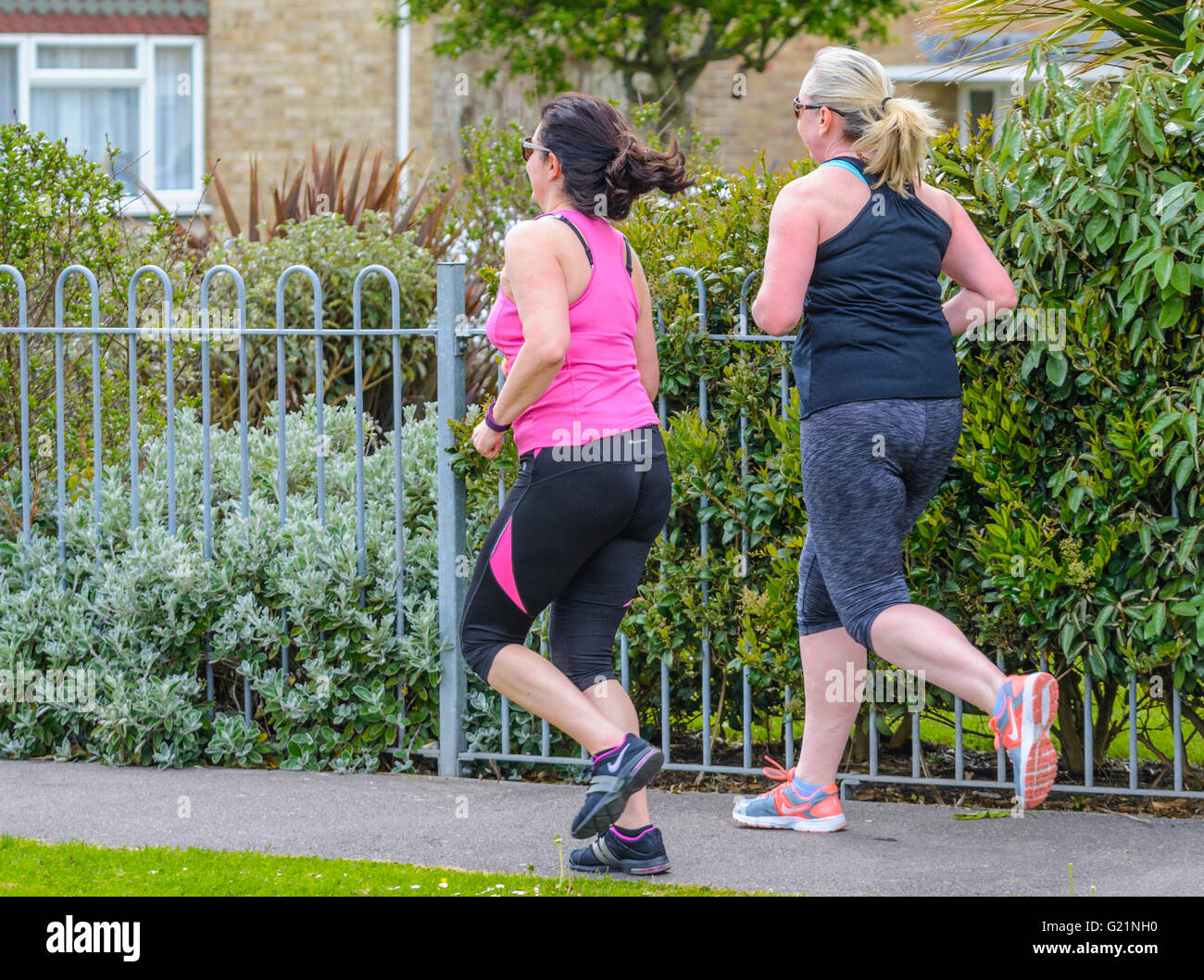 Paar weiblicher Jogger in einer Wohnstraße in Großbritannien. Stockfoto