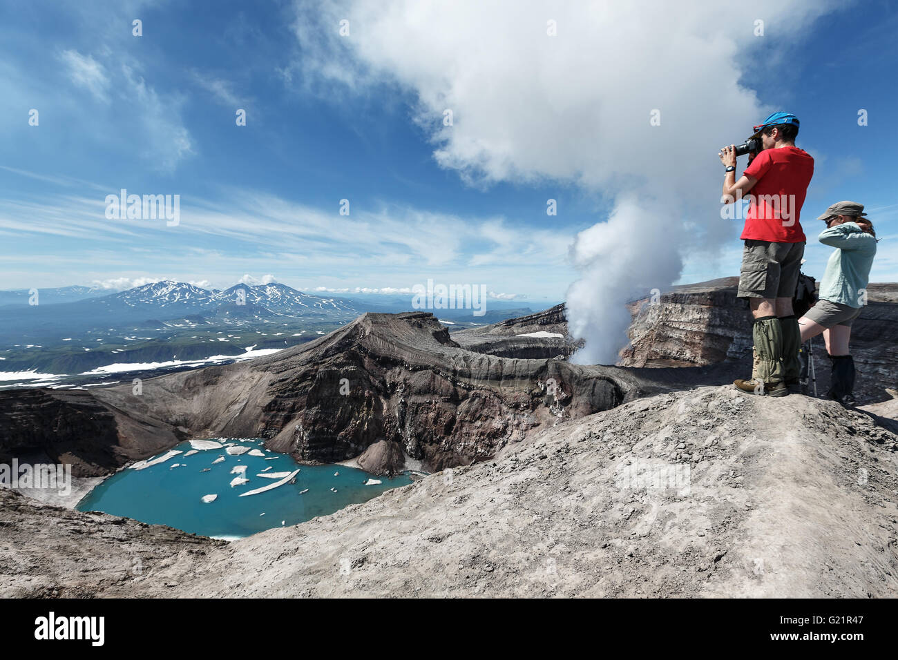 Touristen im Krater des aktiven Gorely in Kamtschatka nimmt ein Bild vulkanische Krater, Kratersee und aktive Fumarolen. Stockfoto