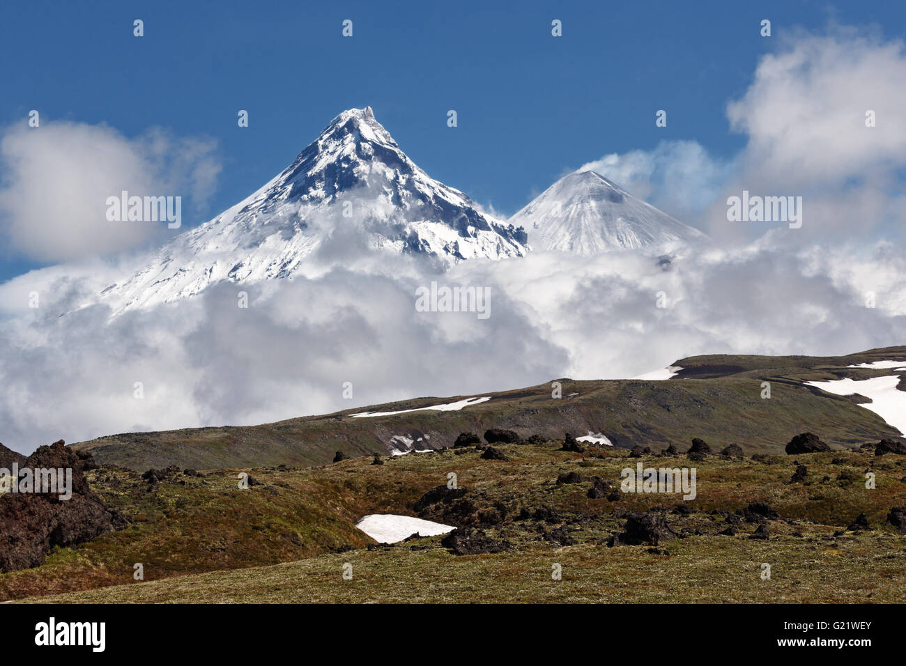 Wunderschöne Berglandschaft der Halbinsel Kamtschatka: Blick auf Kamen Vulkan und aktiven Klyuchevskoy Vulkans an einem sonnigen Tag. Stockfoto