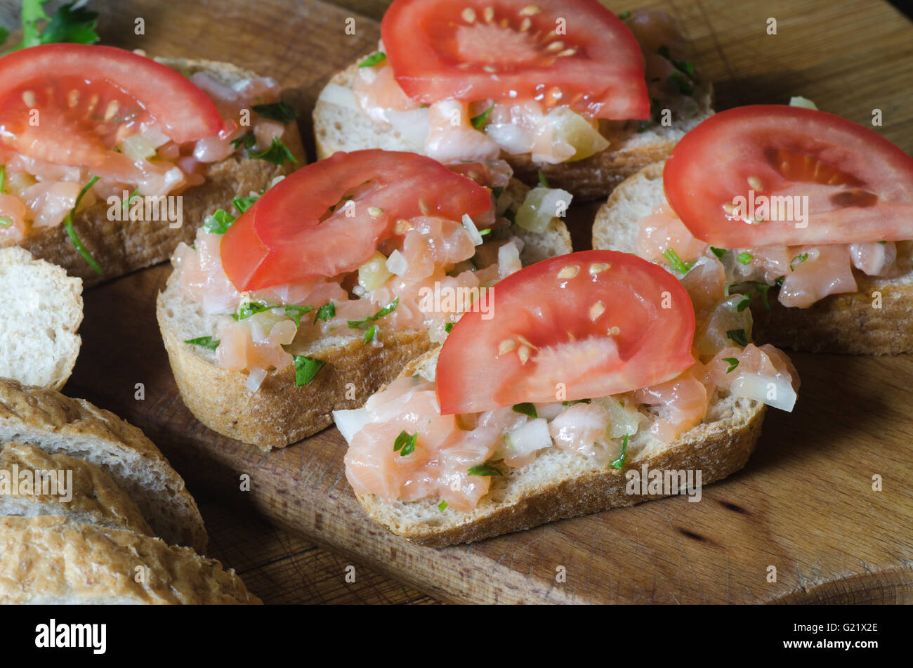 Sandwiches mit Lachs und Tomaten auf Holztisch Stockfoto