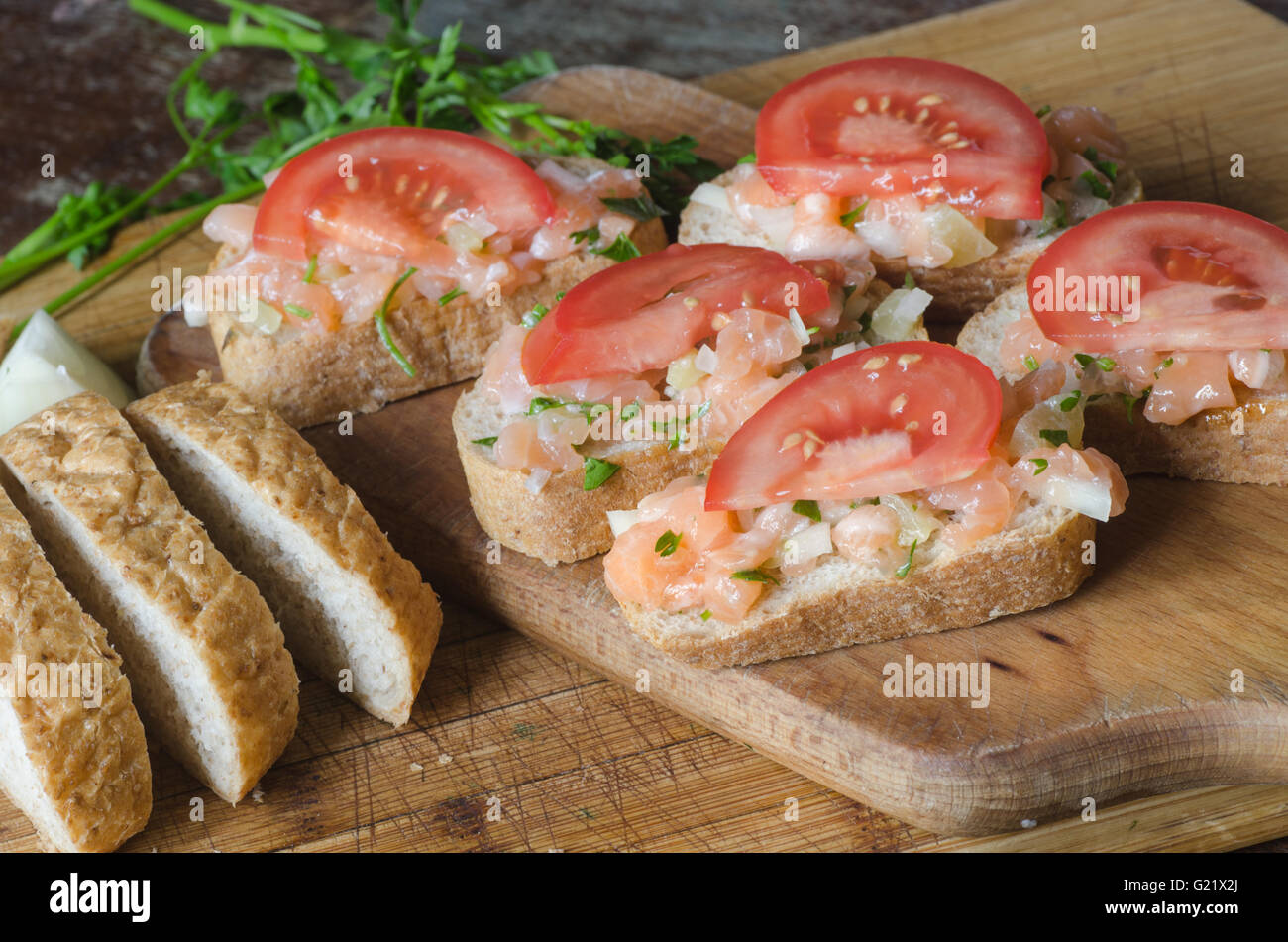 Sandwiches mit Lachs und Tomaten auf Holztisch Stockfoto