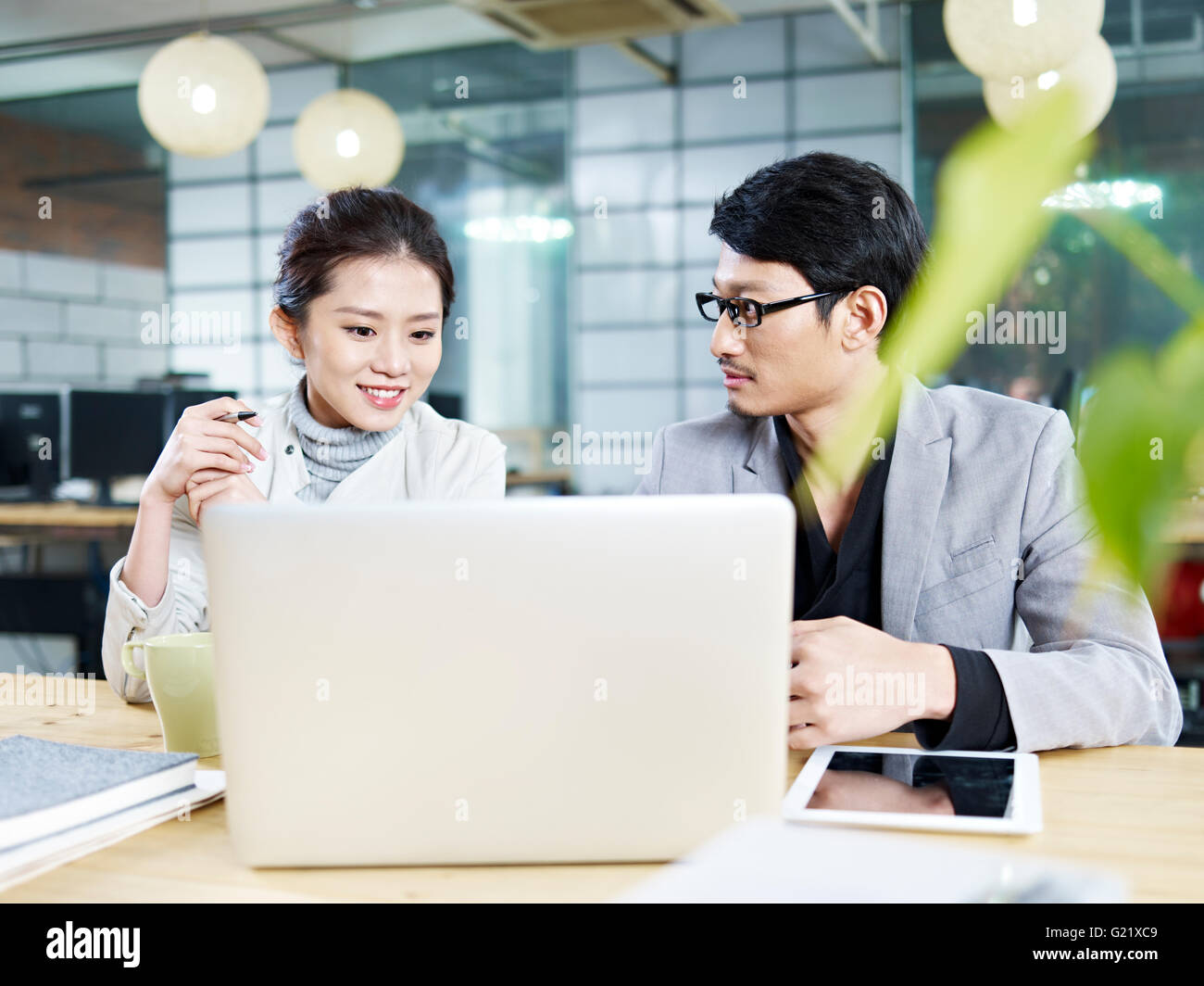 junge asiatische Geschäftsleute sitzen am Schreibtisch arbeiten zusammen mit Laptop-Computer. Stockfoto