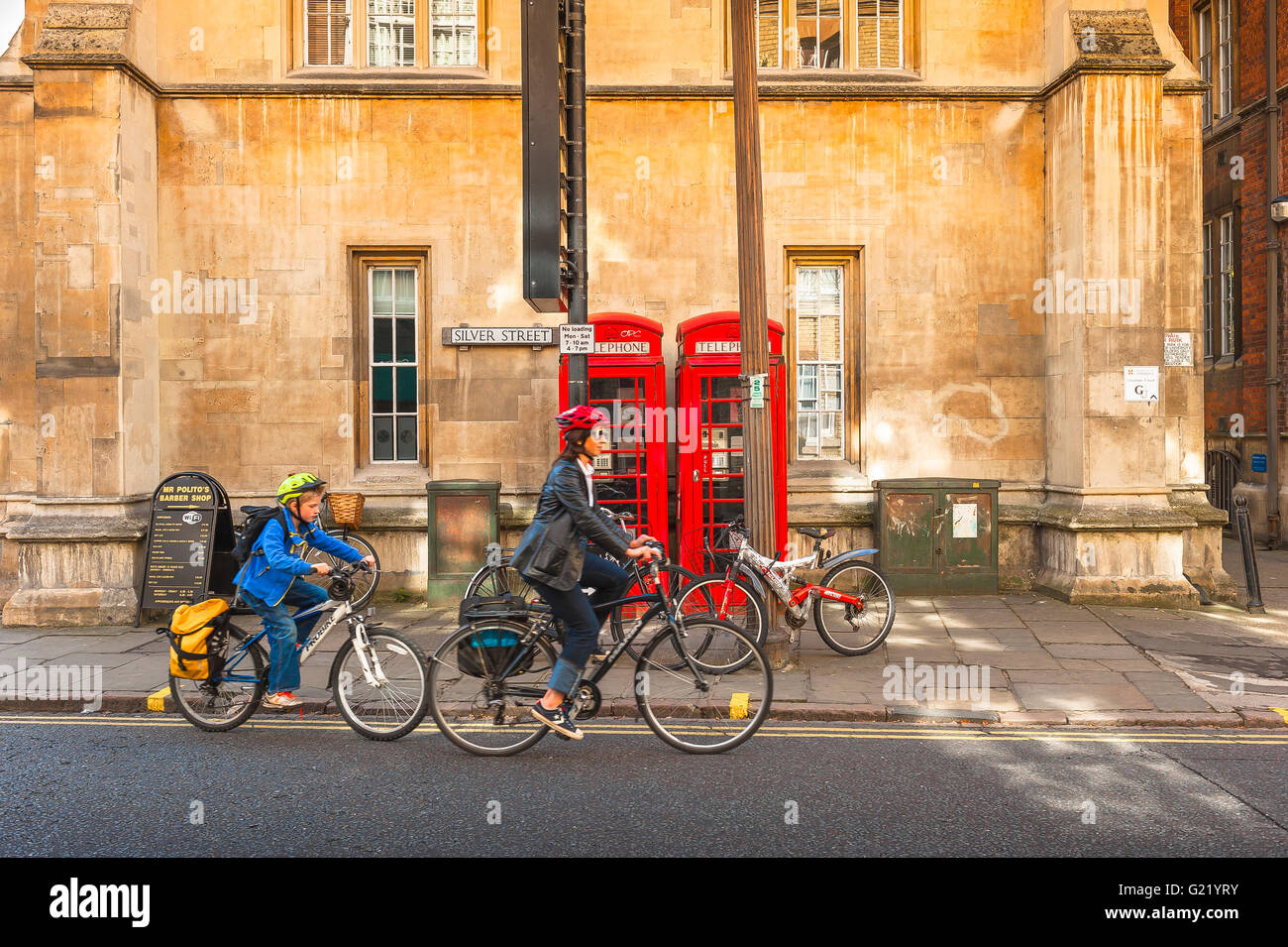 Familienradsport für Mutter und Kind, Blick auf Mutter und Kind, die mit dem Fahrrad auf der Silver Street in der Stadt Cambridge, Großbritannien, England fahren. Stockfoto