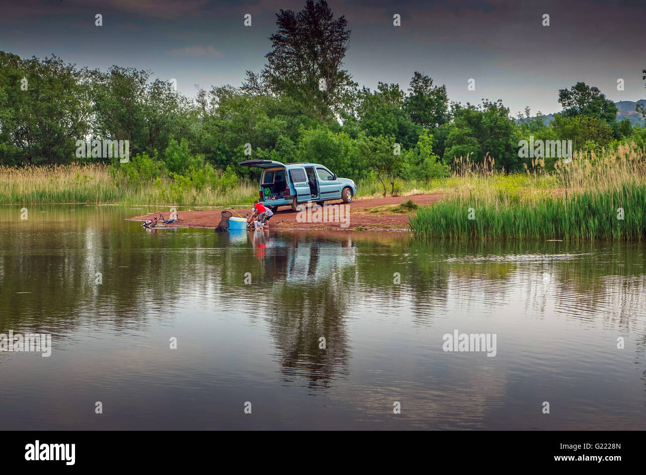 Familie Angeln im Lac de Salagou mit See geparkten Fahrzeug. Stockfoto