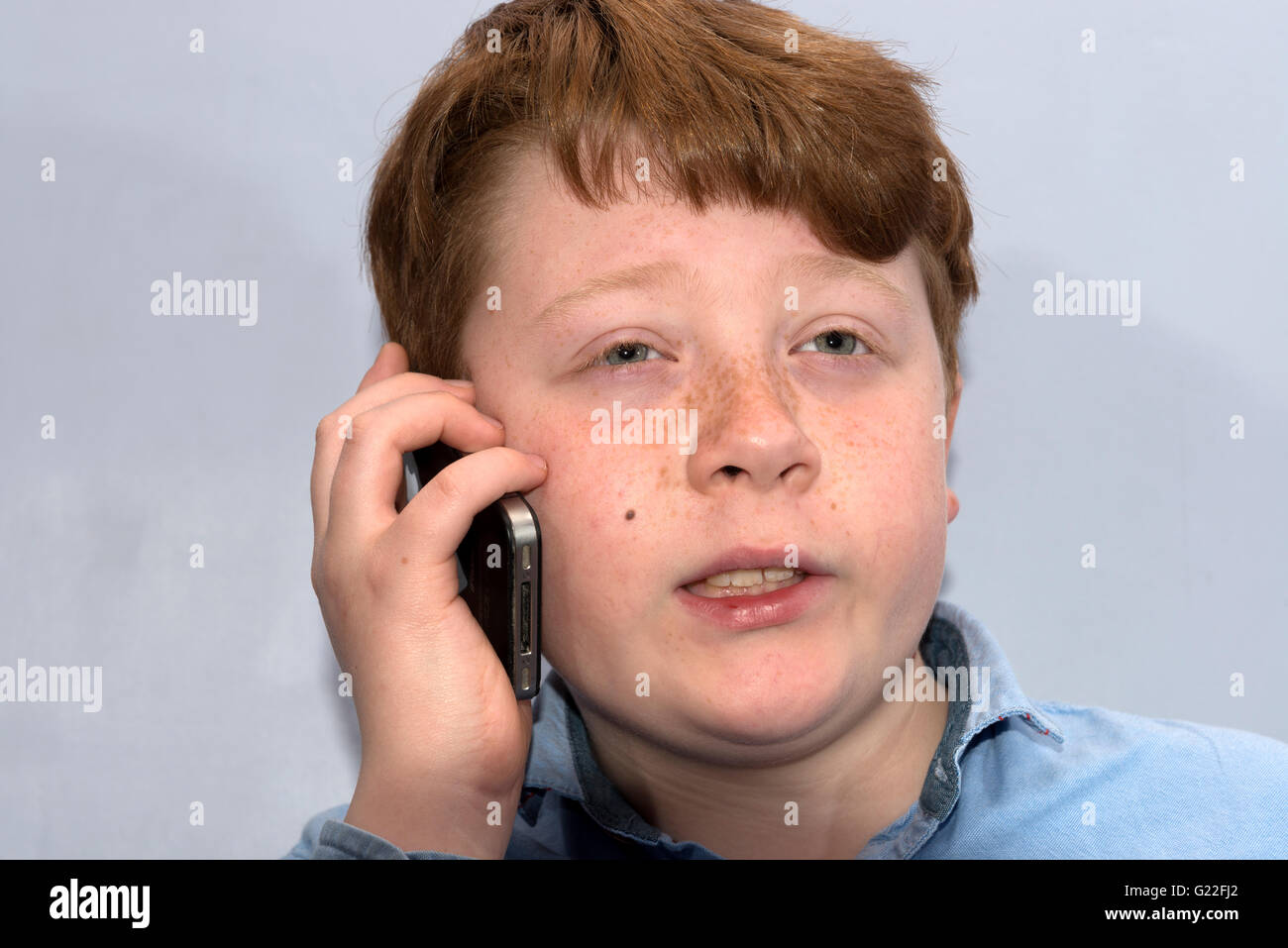 ! 0 Jahre alter Junge im Gespräch mit Freund auf dem Handy Stockfoto