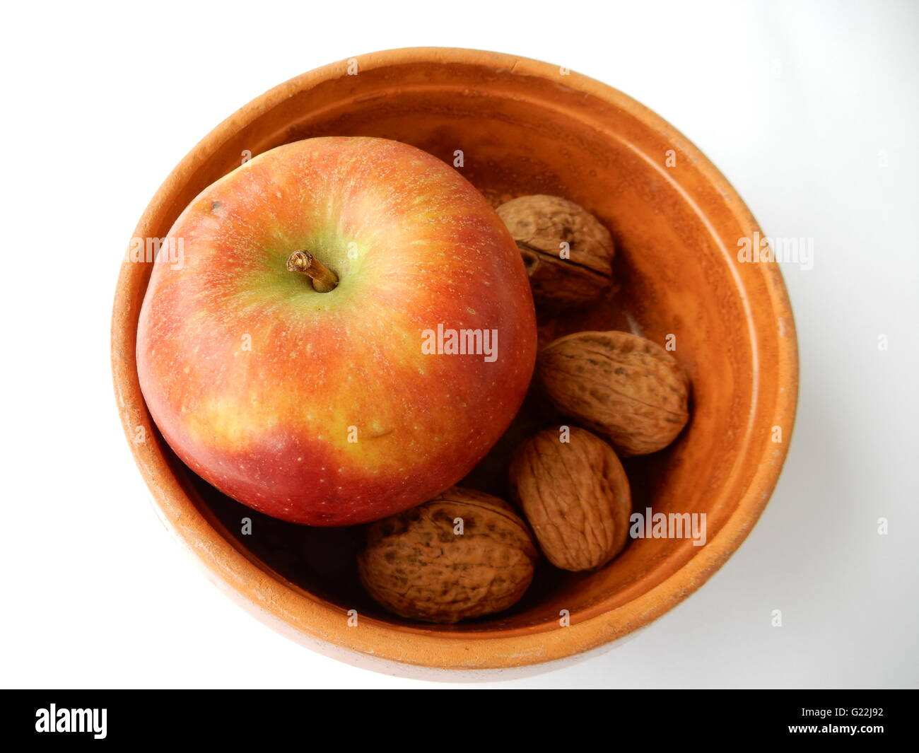 Schüssel mit Apfel und Nüssen Stockfoto