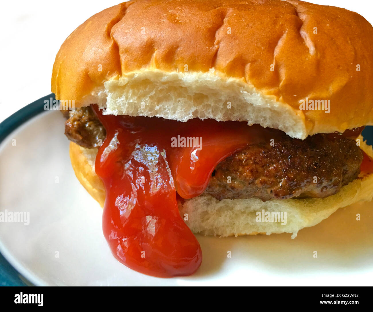 Es sieht fast aus wie dieser Hamburger in einem Brötchen seine Zunge heraus steckt. Stockfoto