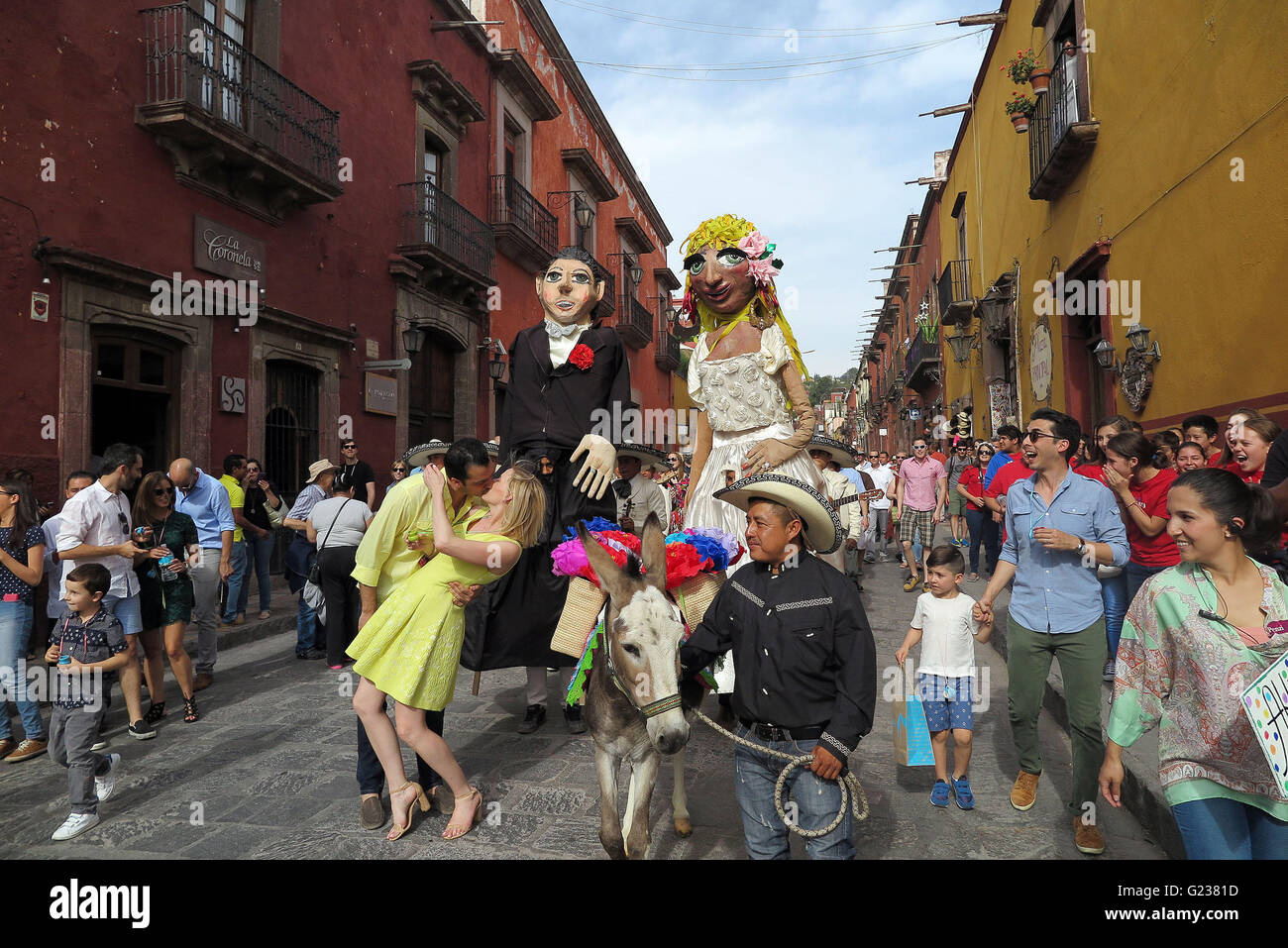 San Miguel De Allende, Mexiko. 18. April 2016. Ein paar Küsse während einer Hochzeit Parade durch die Straßen in San Miguel de Allende. Die Hochzeit-Parade ist komplett mit feierlichen Esel, eine Mariachi-Band und riesige Papier Papiermache Bildnisse (Mojigangas). (Kredit-Bild: © Julie Rogers / via ZUMA Draht) Stockfoto