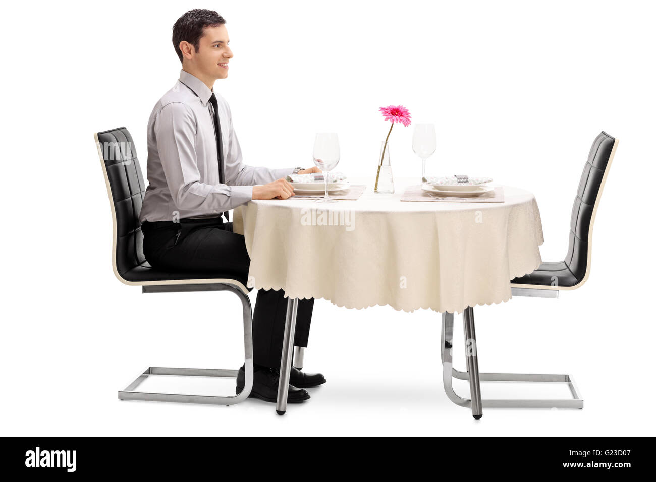Junger Mann sitzt an einem Tisch im Restaurant und wartet auf seine Datum isoliert auf weißem Hintergrund Stockfoto