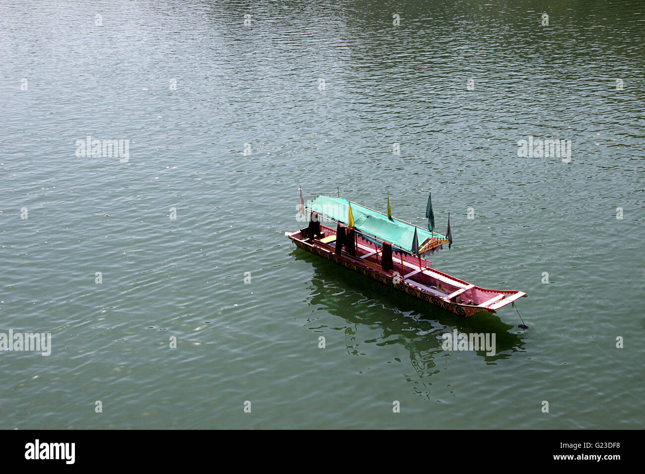 Touristenboot mit schattigen Baumkronen warten auf Besetzung Stockfoto