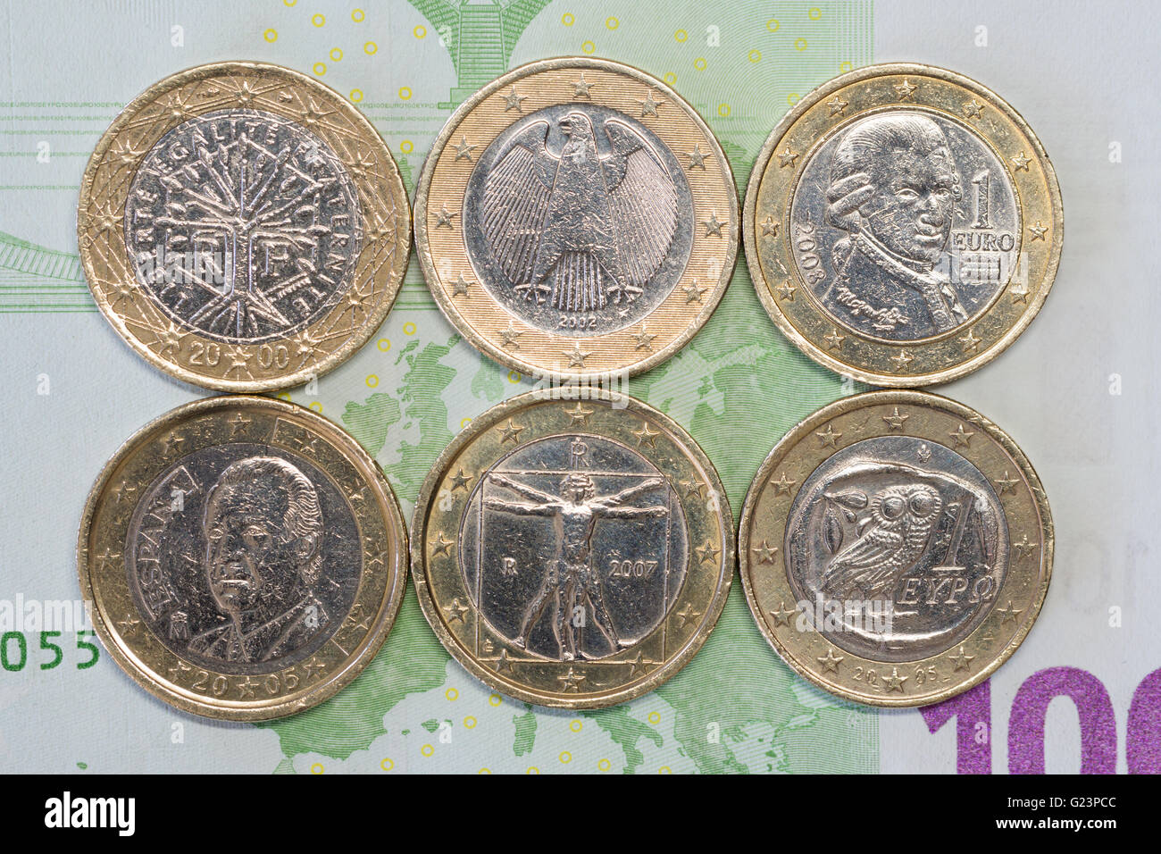 1 € Münzen Euro für drei nördlichen und drei südeuropäische Länder auf einer 100 Euro-banknote Stockfoto