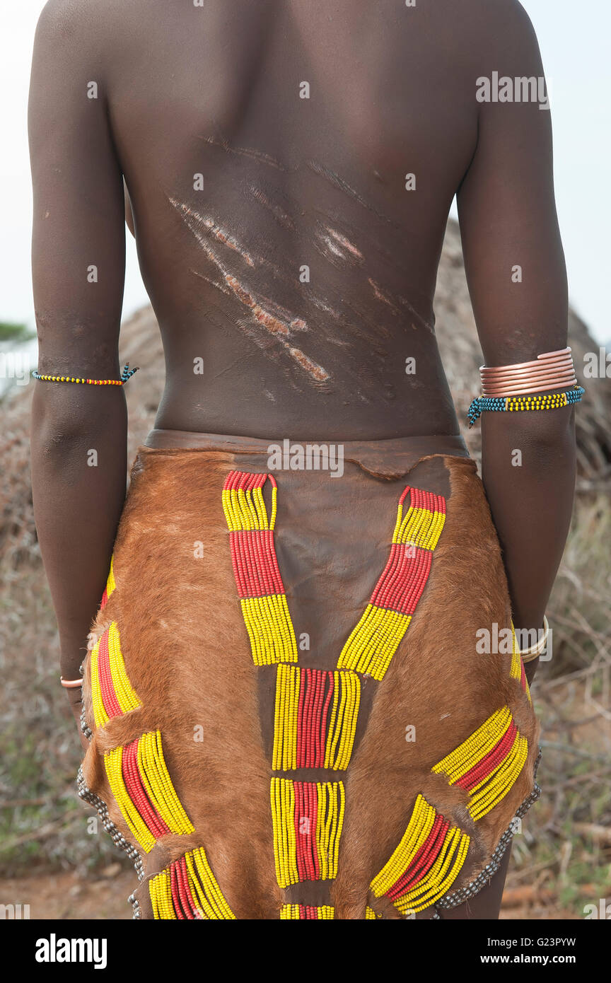 Hamar junge Frau mit rotem Lehm im Haar und mit Narben und Spuren auf dem Rücken, Südäthiopien gepeitscht Stockfoto