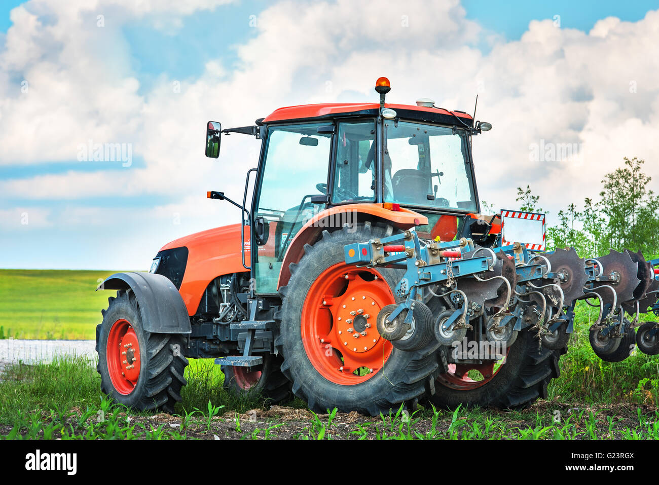 Modernen roten Traktor auf den landwirtschaftlichen Bereich. Stockfoto