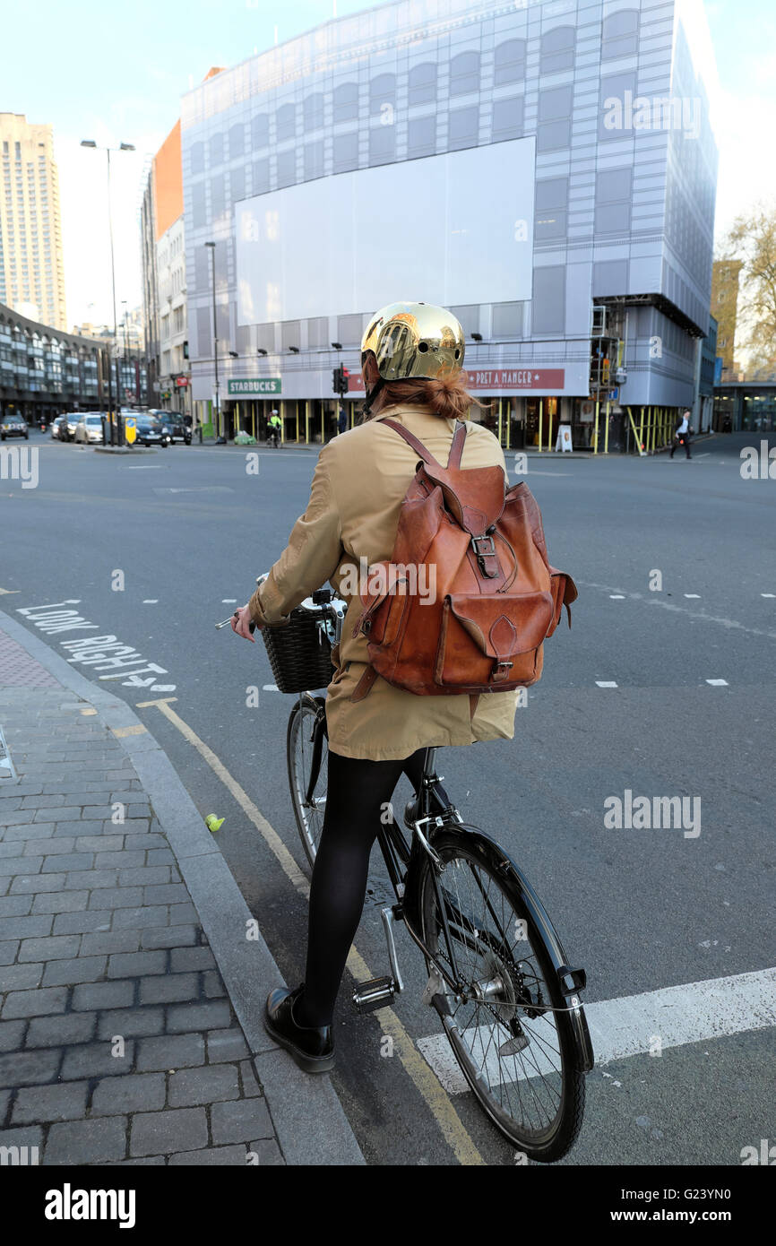 Junge weibliche Radfahrer mit einem goldenen Helm und Leder Rucksack auf Fahrrad an Goswell Road & Old Street London UK KATHY DEWITT Stockfoto