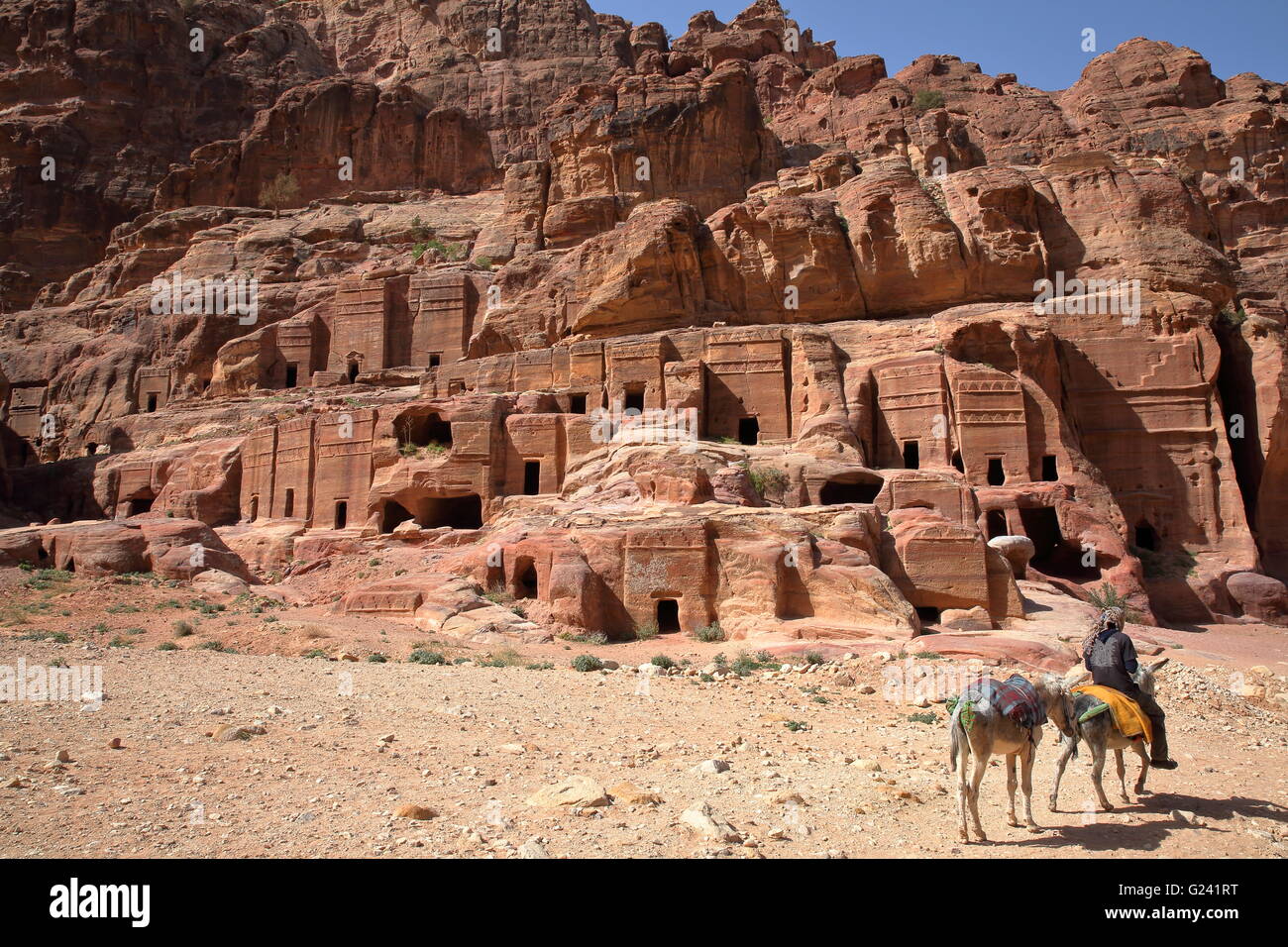 Die Straße von Fassaden in Petra, Jordanien, ein Beduinen-Mann reitet seinen Esel im Vordergrund Stockfoto