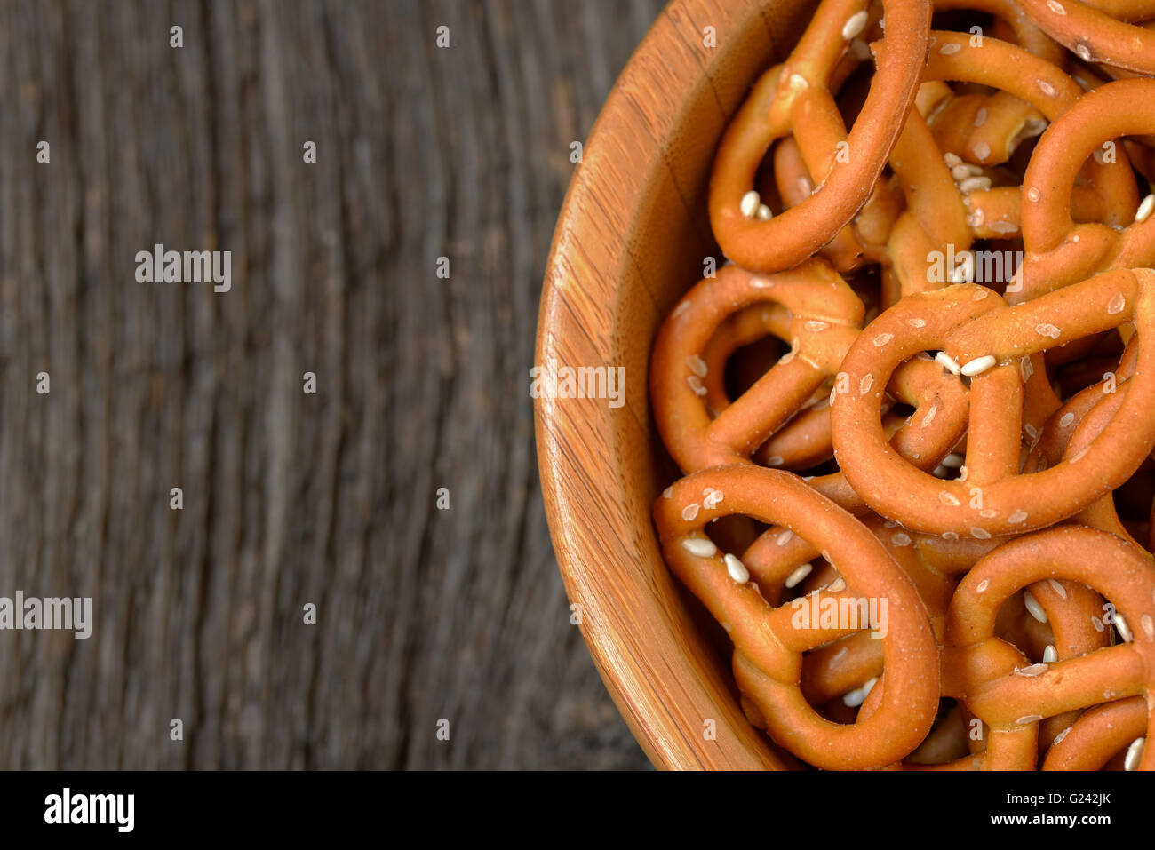 Brezeln gebacken mit Sesam in einer Holzschale - Draufsicht, rustikalen Blick. Stockfoto