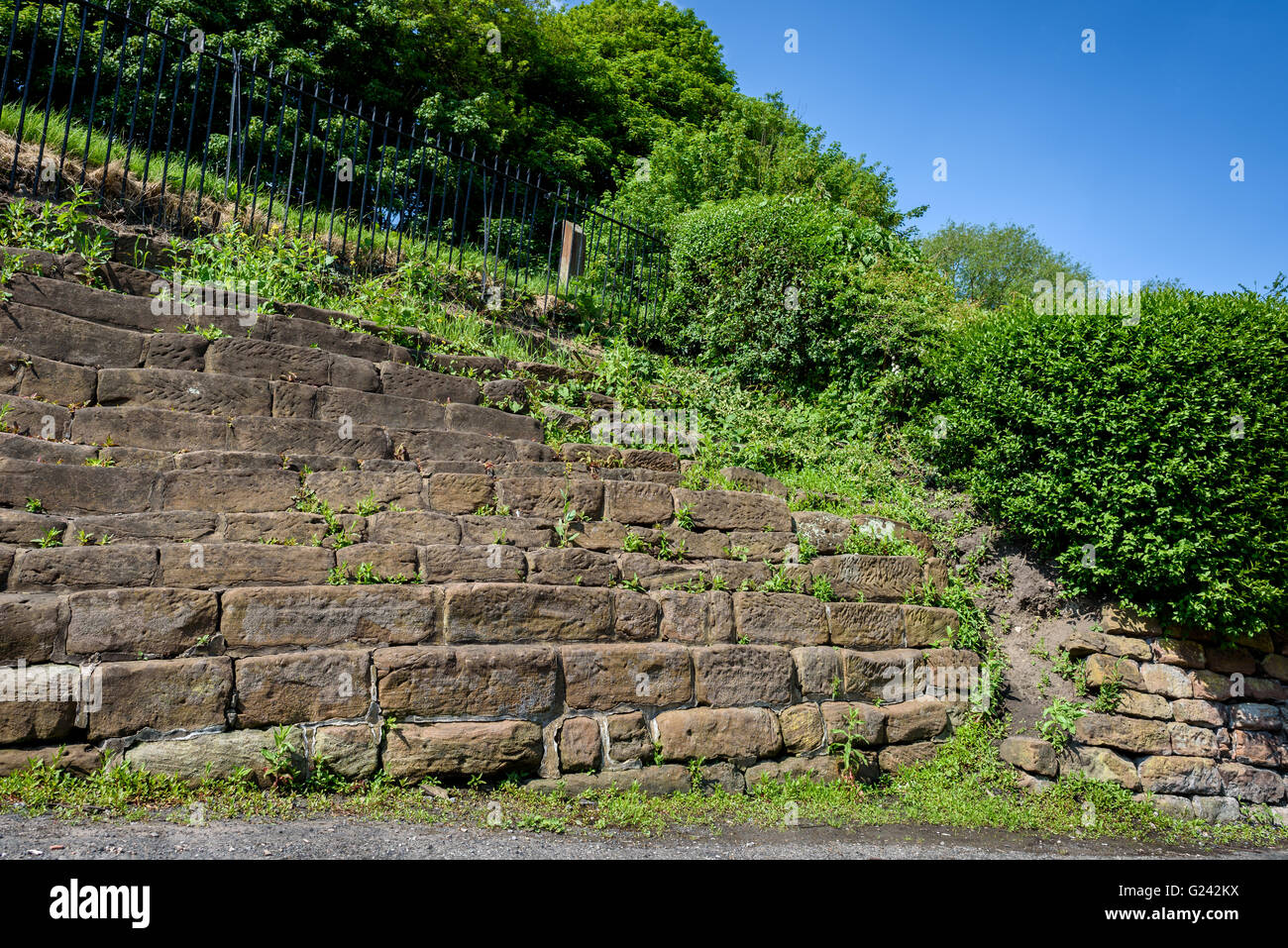 Alten Sandstein-Schritte auf einer Garten Bank. Stockfoto